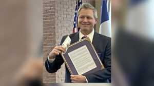 Man holding framed document